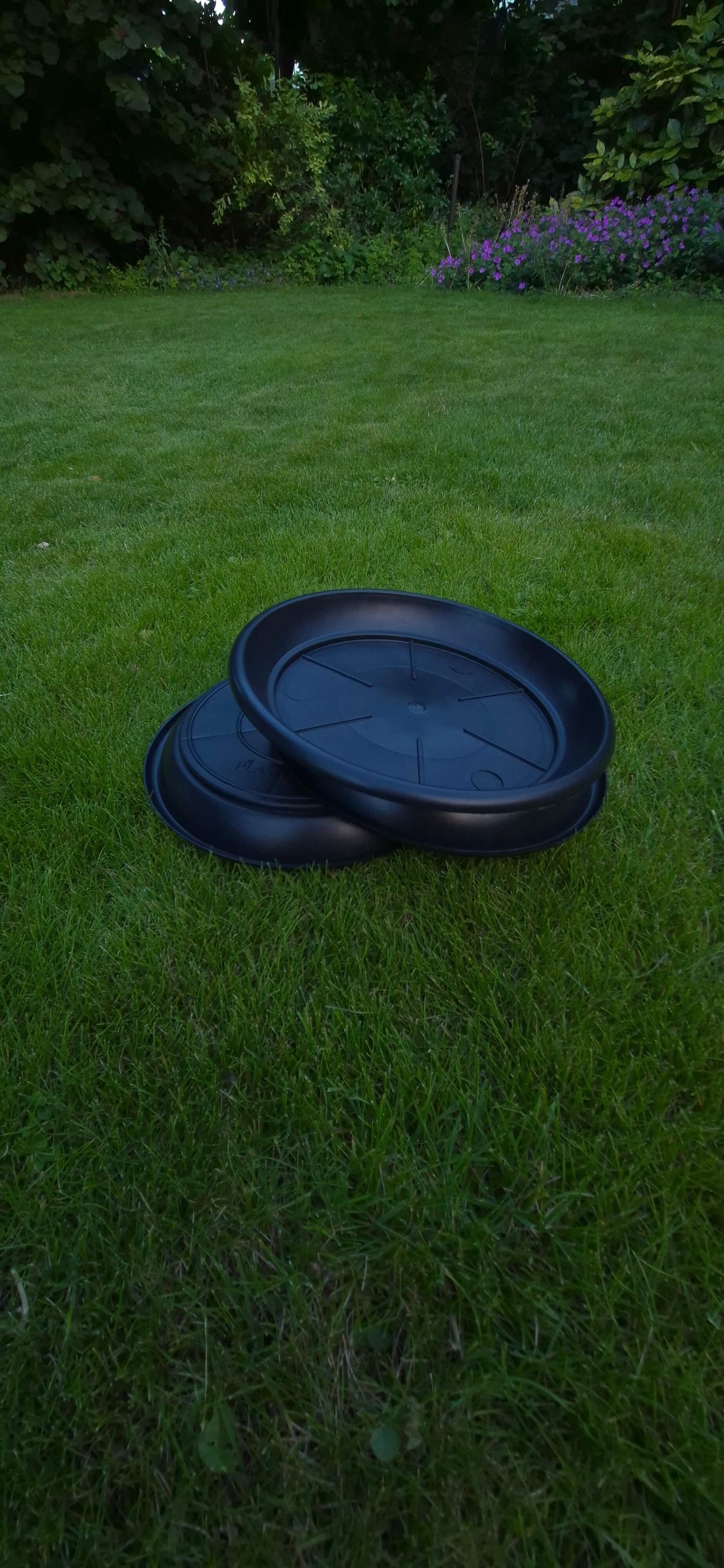 Drie zwarte driptrays op gras