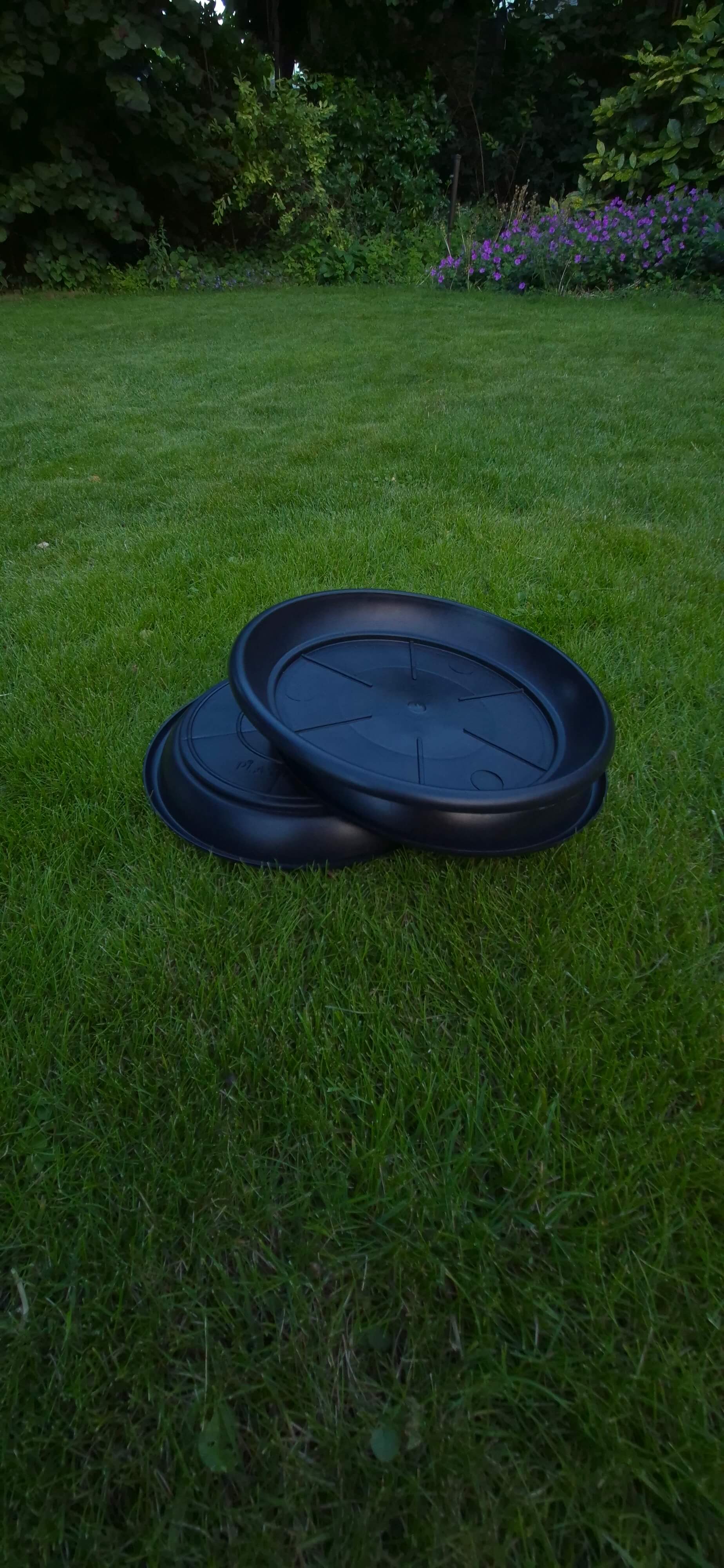 Drie zwarte driptrays op gras